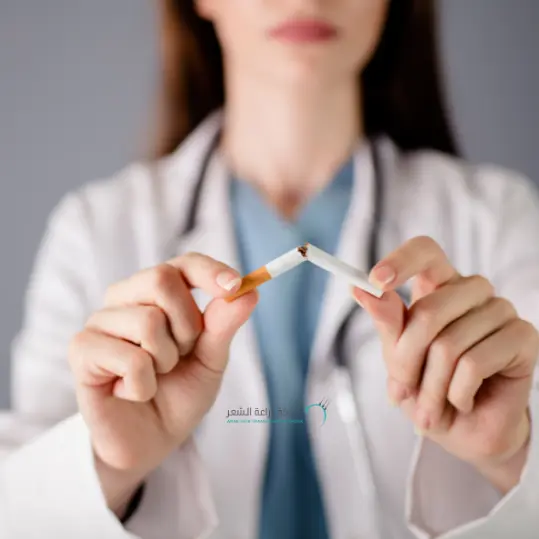 طبيبة تقوم بكسر سجارة توعية للاثار السلبيه للتدخين وتساقط الشعر الذى يتاثر بالتدخين بشكل سلبي